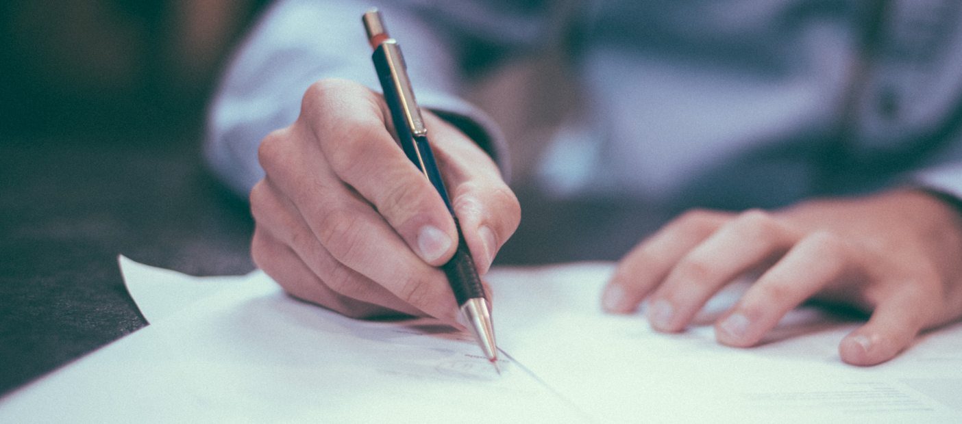 Hand writing on paper with a pen for academic research.
